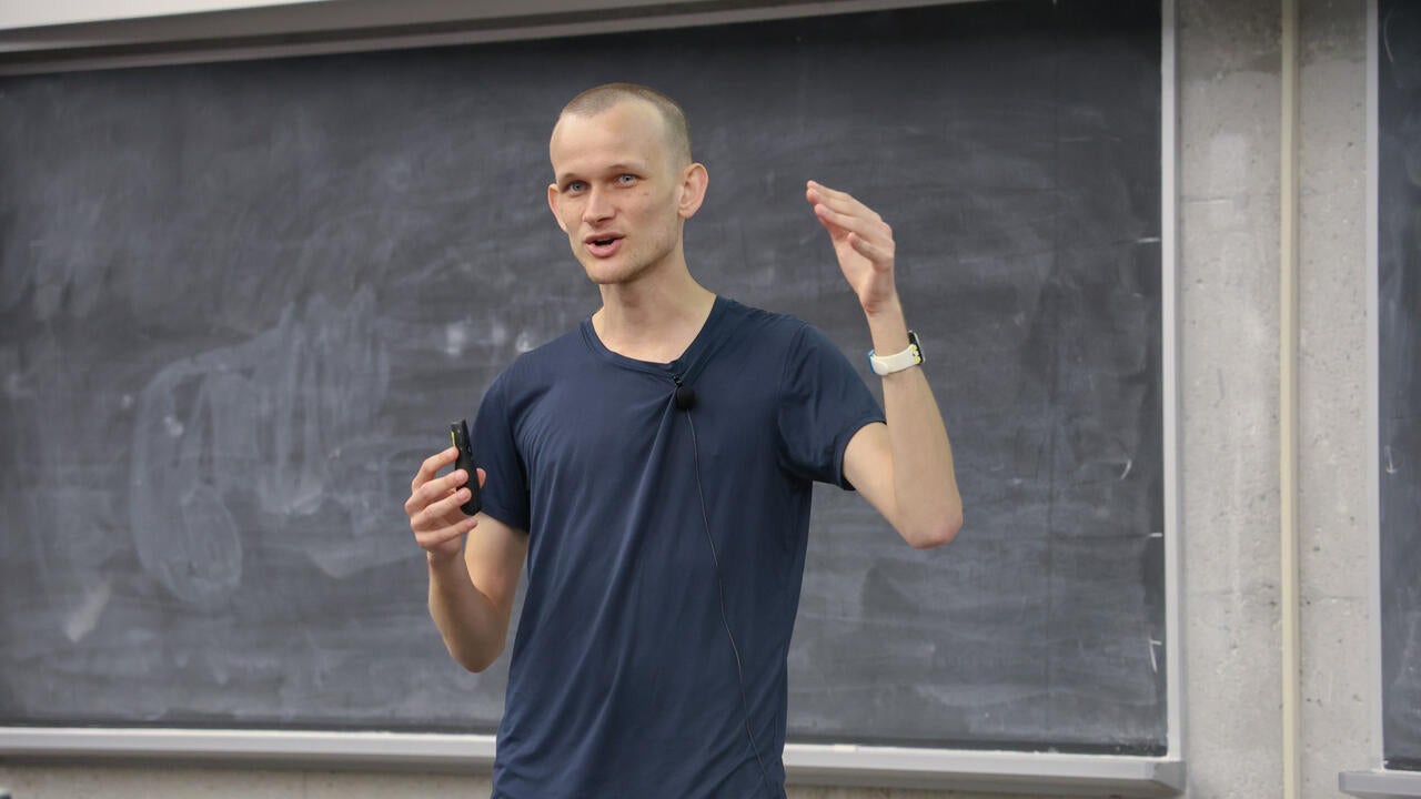 Vitalik Buterin lectures in front of a blackboard 