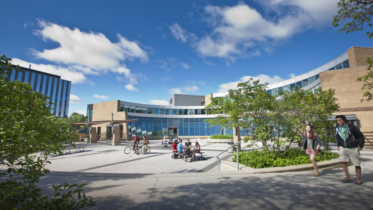 Students walk and sit outside the Student Life Centre