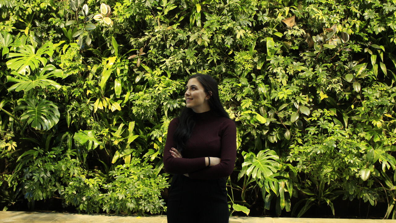 Girl looking to the left with a plant background