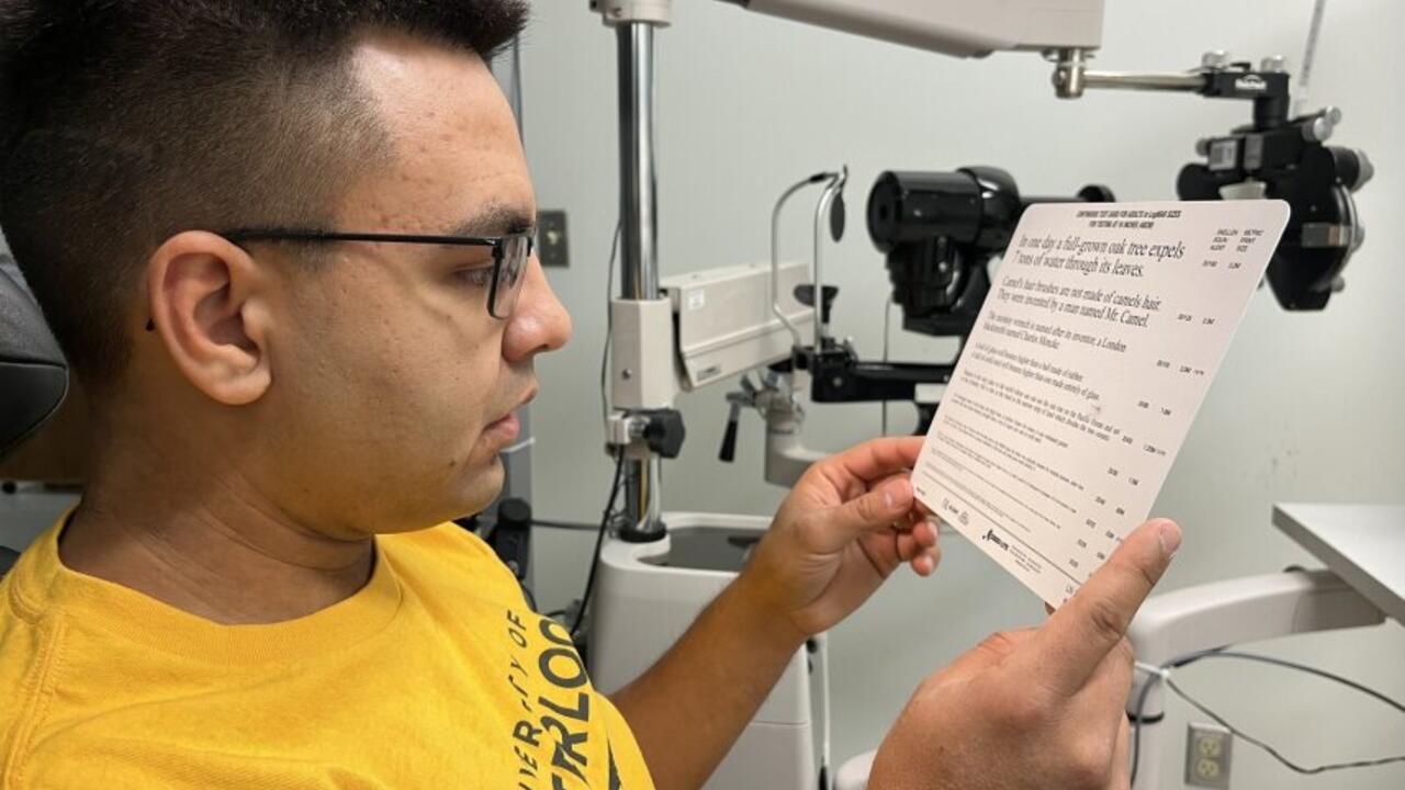 University of Waterloo Indigenous student, Jeremiah Hyslop, reading text on a standardized eye exam card