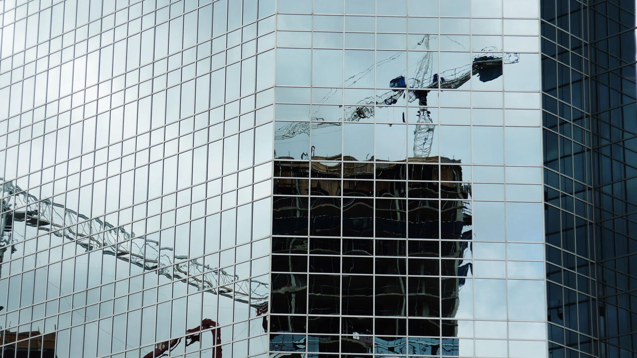 reflection of a crane in a high-rise building
