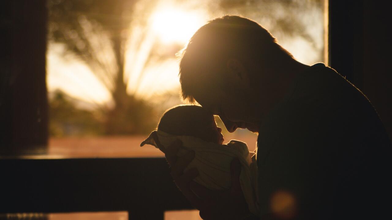 Man with baby at sunset