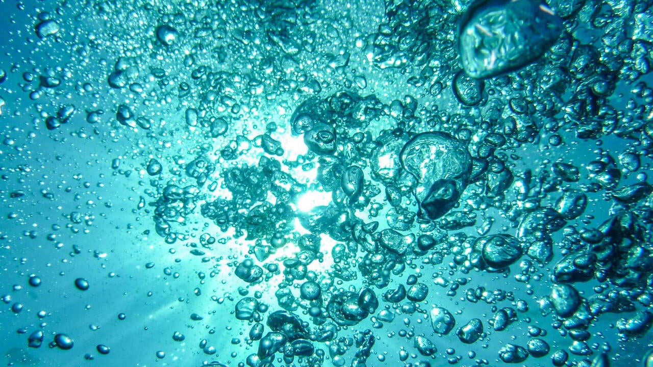 Underwater air bubbles rising up towards surface