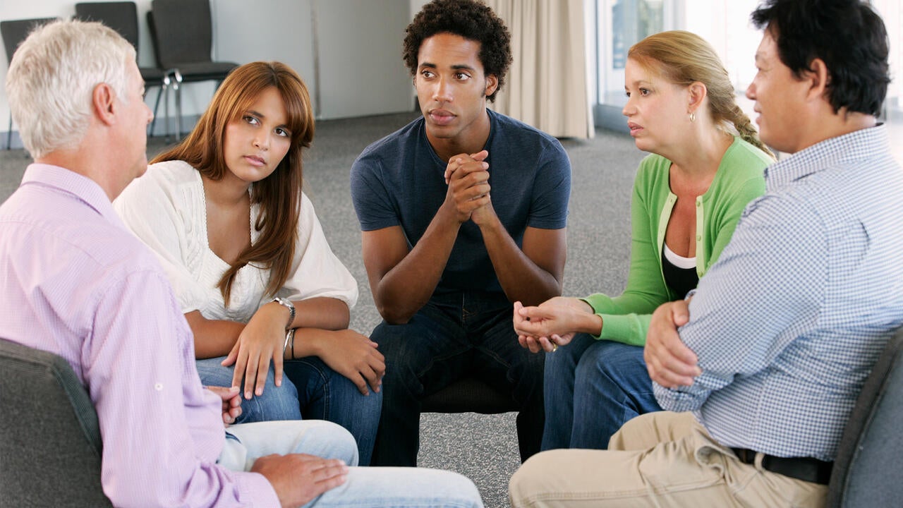 People sitting in a group listening to a group ther