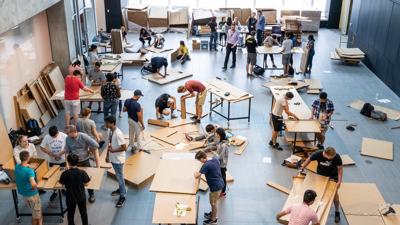 Large group of students working with pieces of cardboard