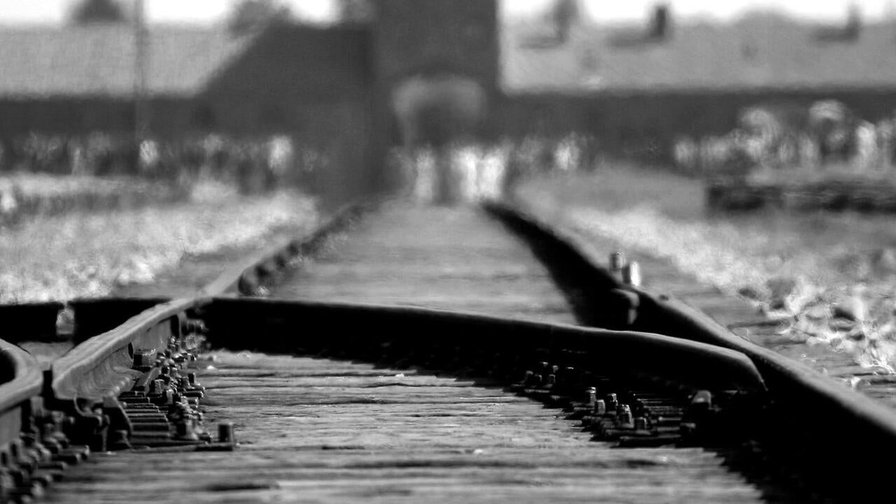 Train tracks going  towards concentration camp