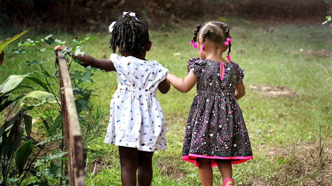 two little girls walking together in nature