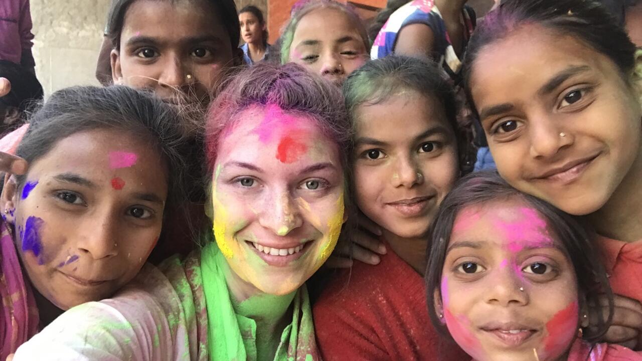 Bridget smiling with children with paint on her face