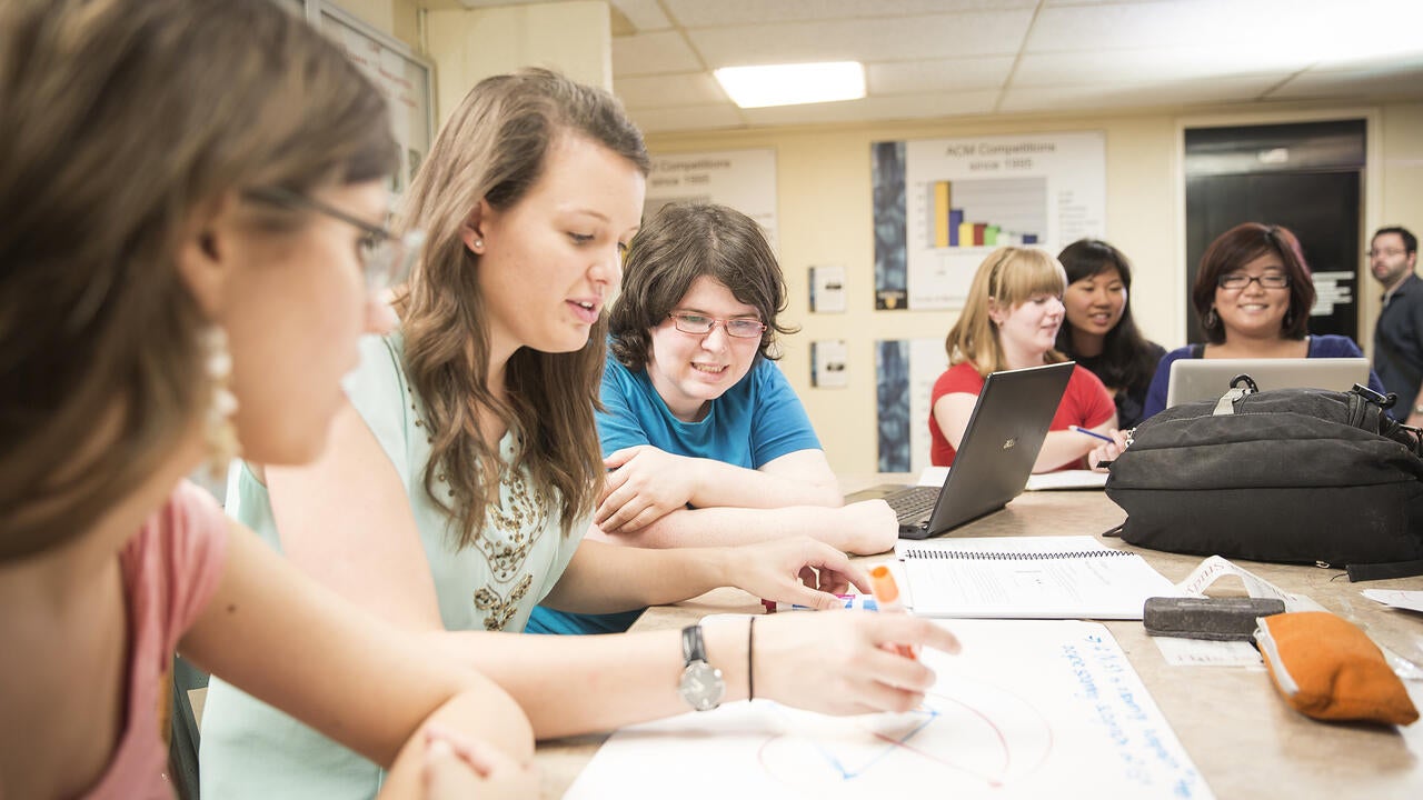 Girls solving math problems in a classroom.