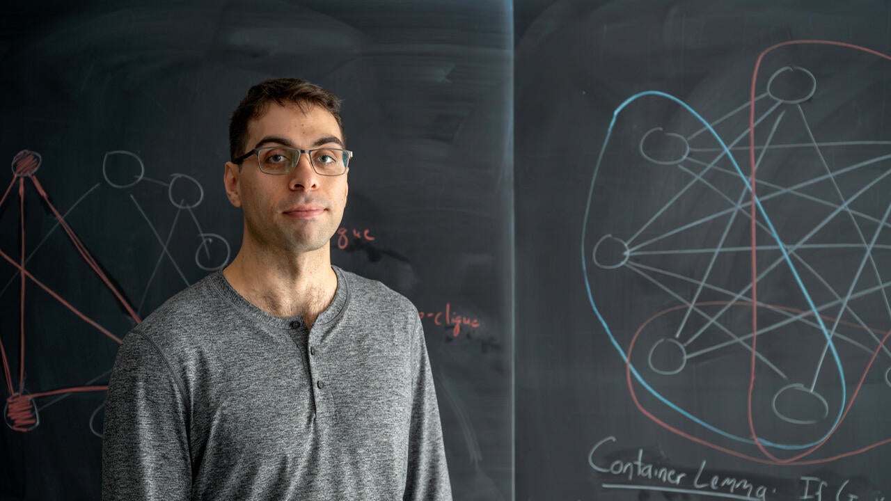 Cameron Seth standing in front of blackboard