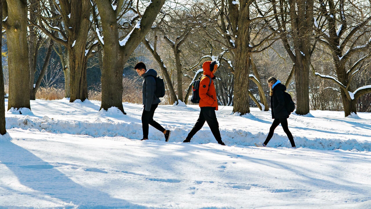 Waterloo students walking across a path on a cold winter day