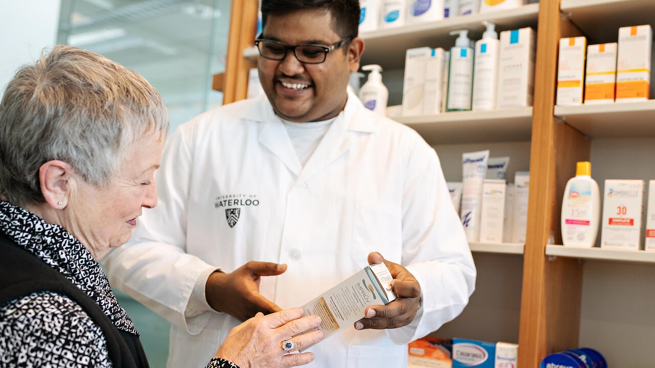 Waterloo pharmacy graduate assisting patient in a pharmacy