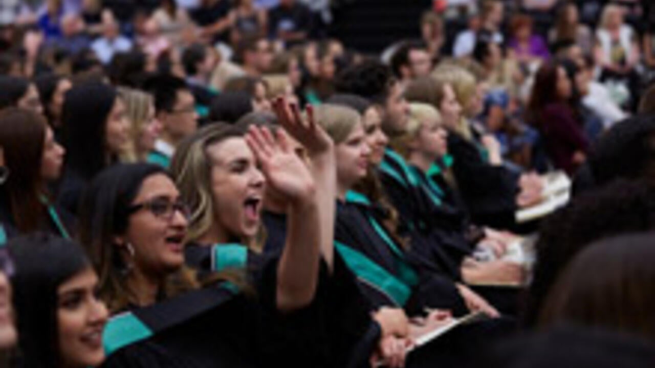 Waterloo graduates cheering while seated for convocation 