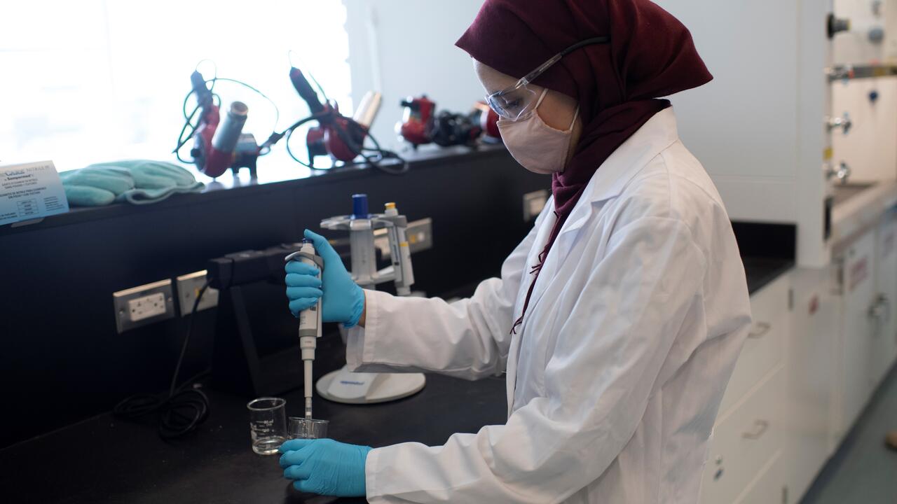A woman works with materials in a lab