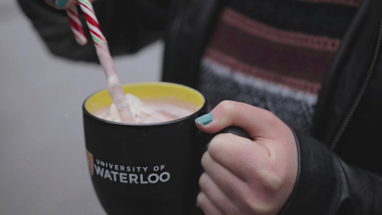 Candy cane stirring hot chocolate in UWaterloo mug