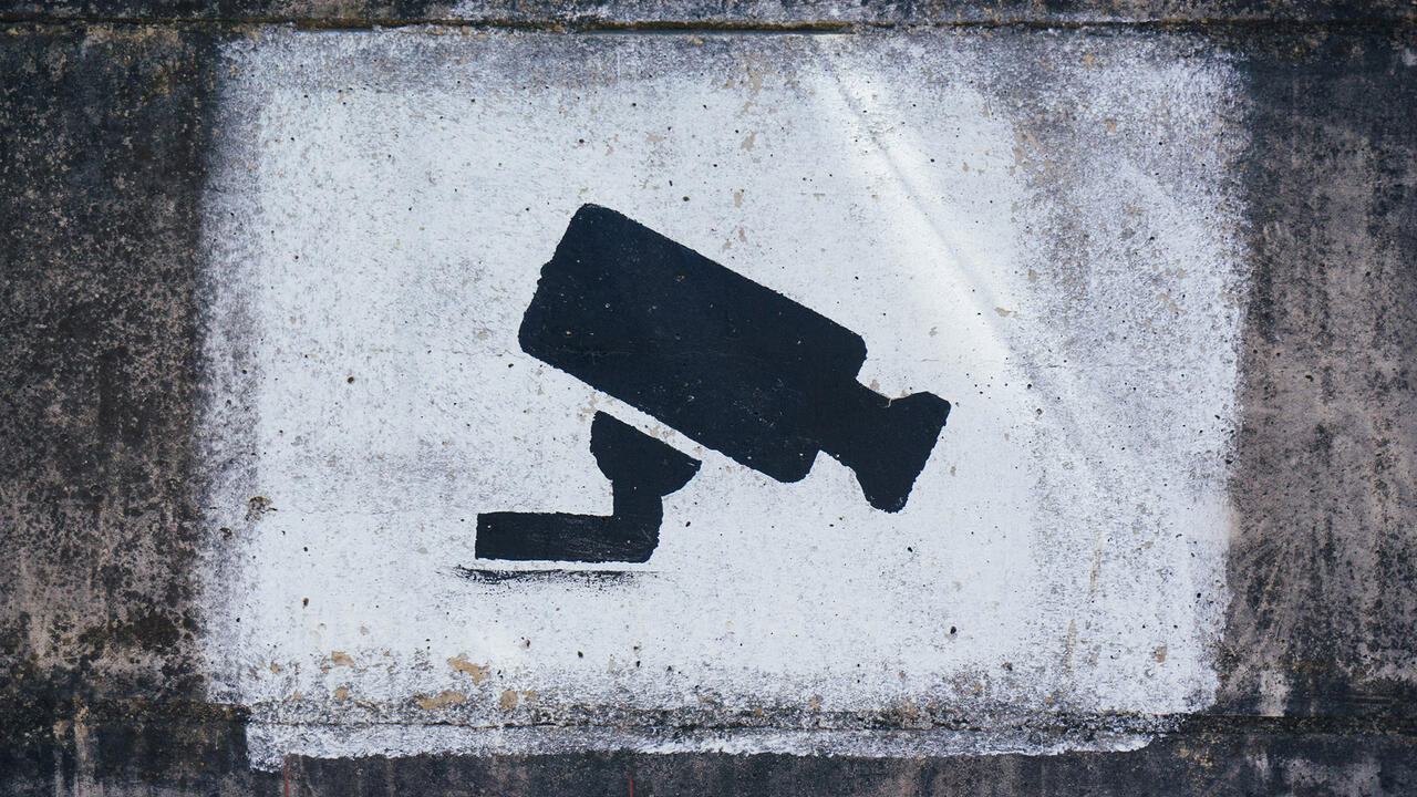 An illustration of a security camera spray painted on a wall