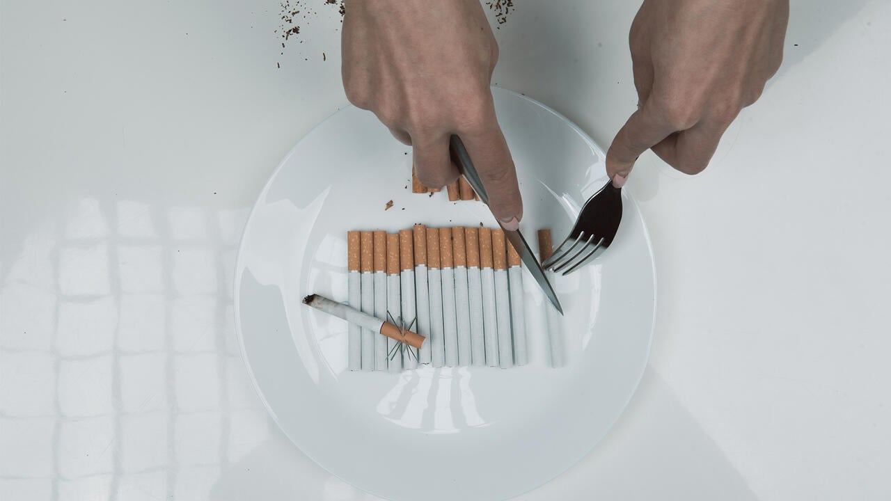 Images shoes hands cutting a plate of cigarettes