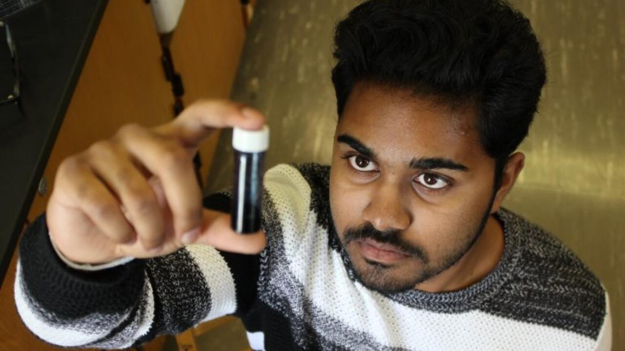 Duleeka Ranatunga examines a vial of hydrogel for use in cancer research.