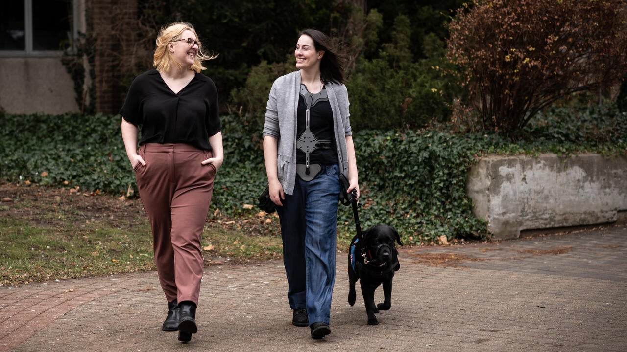 Emma and Samantha walking with service dog