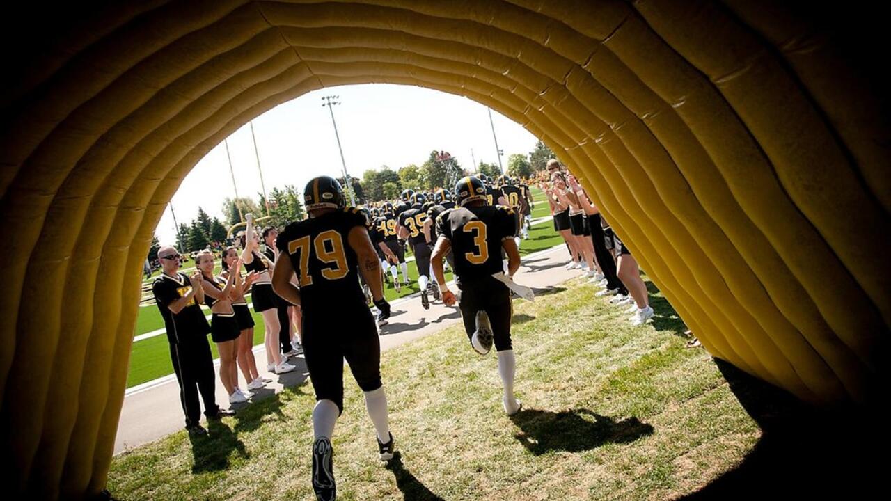 Football players run onto the field