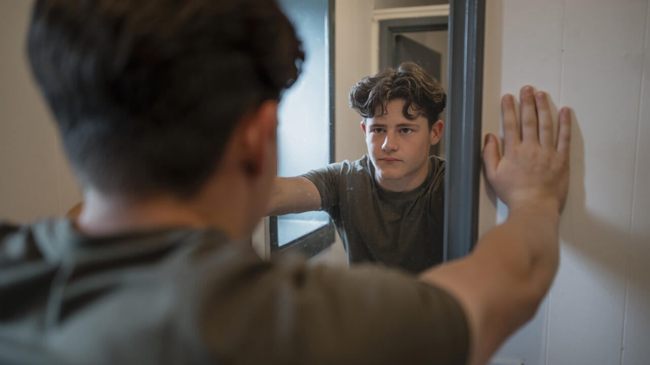 Male youth looking into mirror