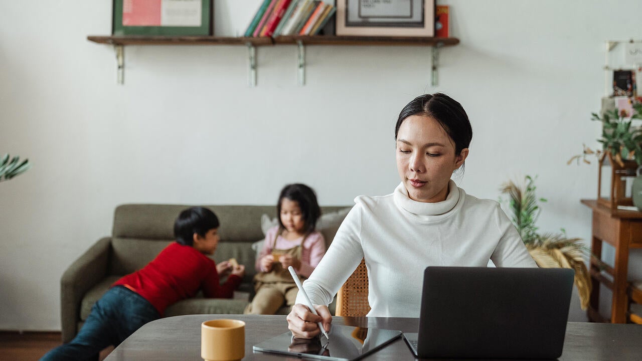 Women working from home with kids in the back 