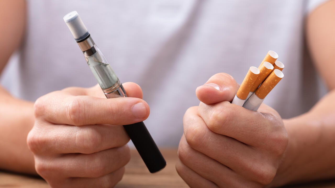 Man Holding Vape And Tobacco Cigarette 