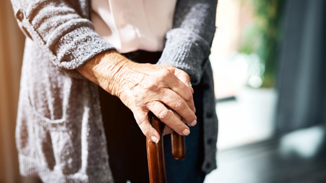 A lady standing with a walking stick 