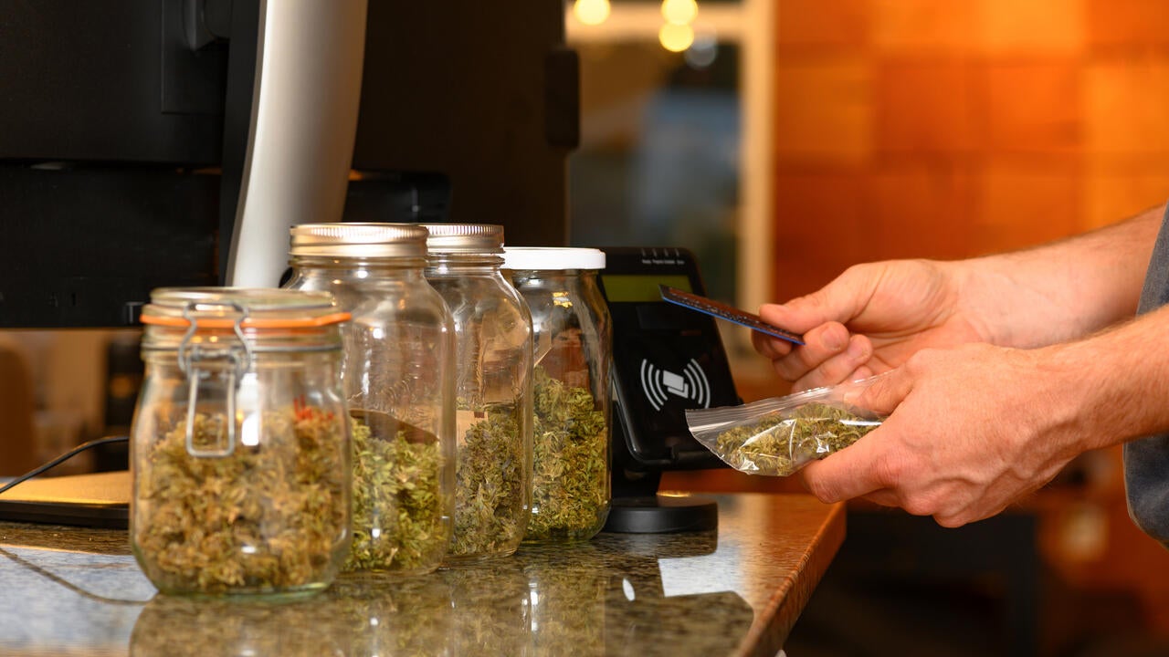 Someone paying by credit card for marijuana at a cannabis dispensary