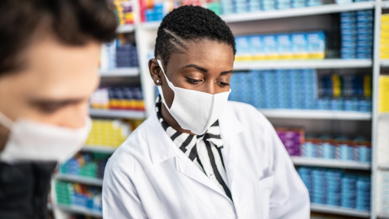 A female pharmacist explaining something to a male customer 