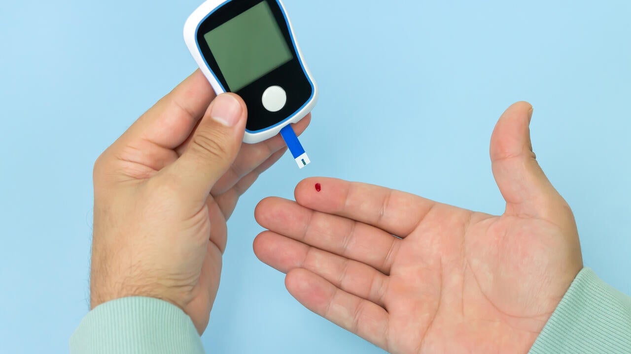 Man checking blood sugar level with glucometer.