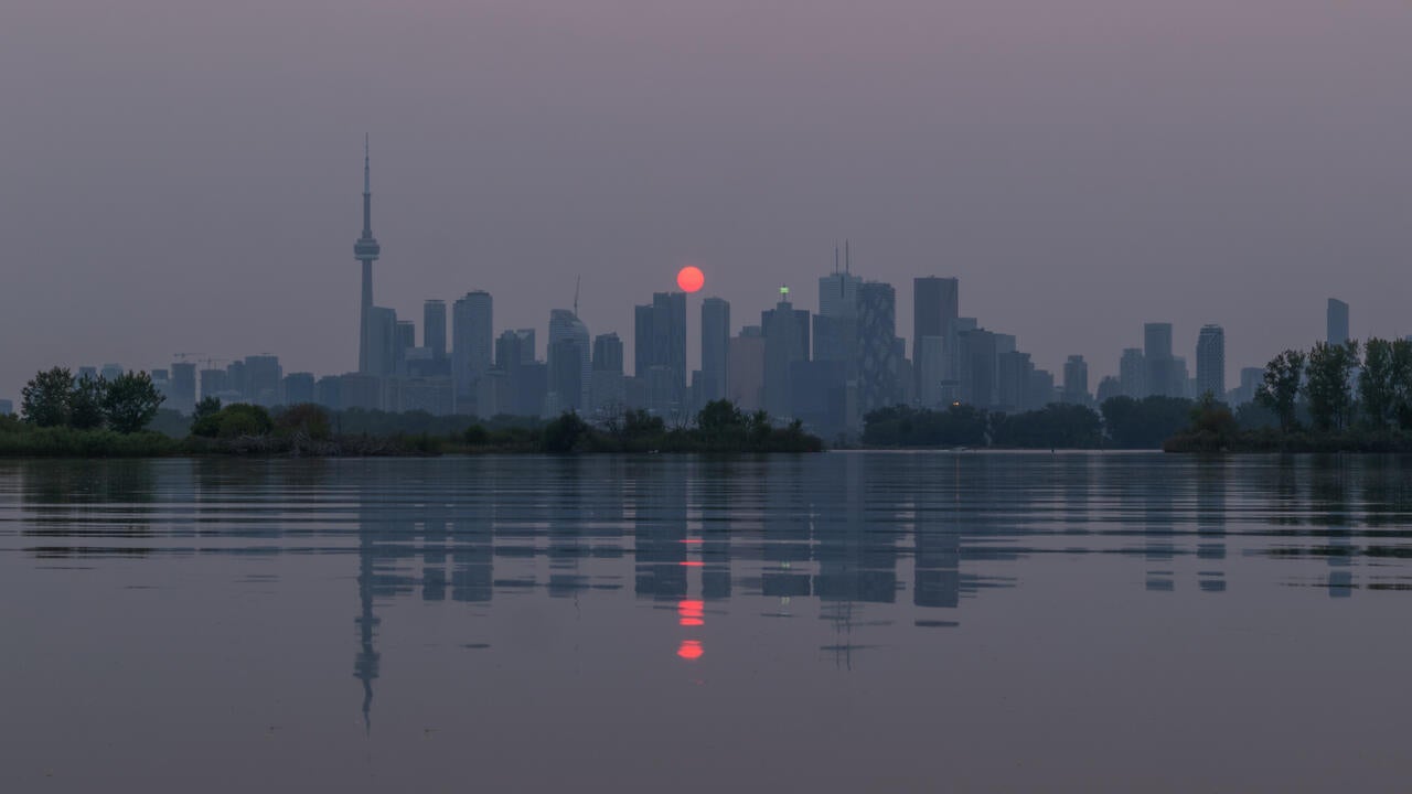 Red sunset over Toronto's skyline caused by wildfire pollution.