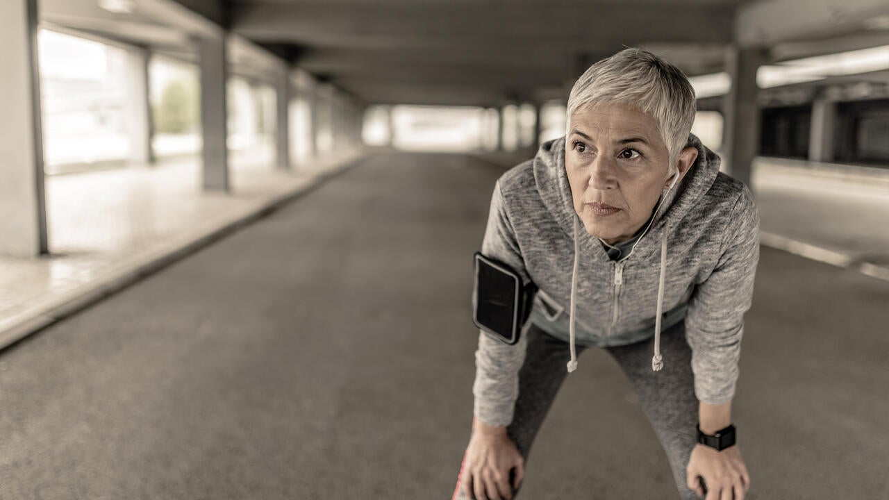 Portrait of a woman fighting breast cancer, resting after jogging. 