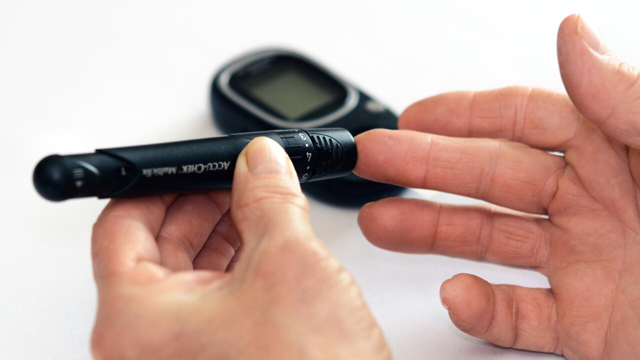 Person holding a glucose monitoring meter