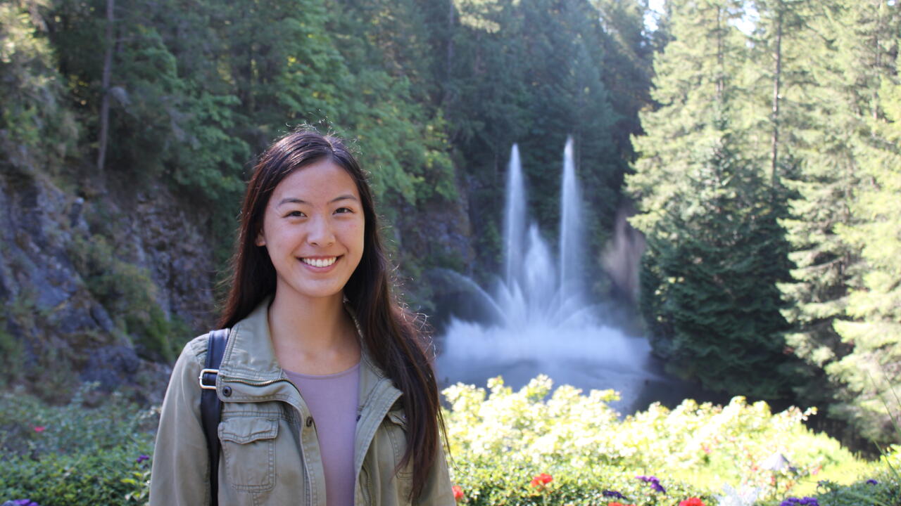 Kinesiology graduand Tina Jiao in front of a garden