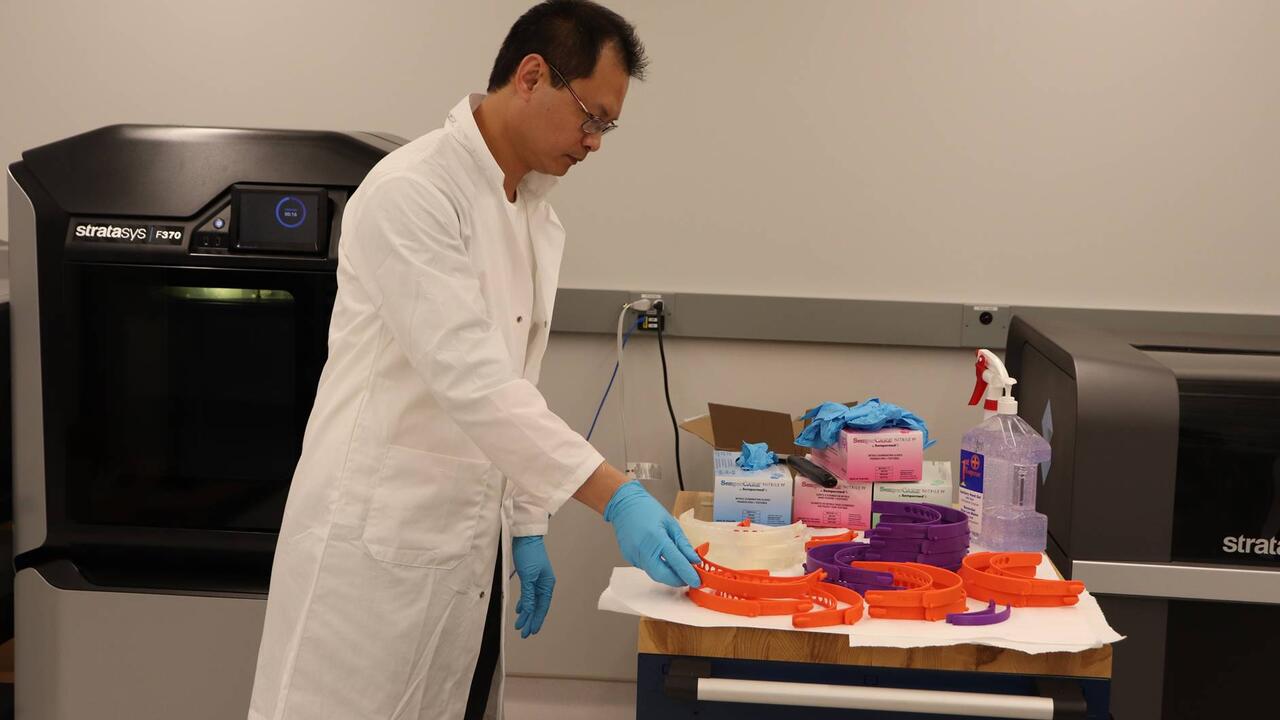 Jerry Ratthapakdee, a MSAM lab technician, takes a completed headband out of a 3D printer in Waterloo’s Multi-