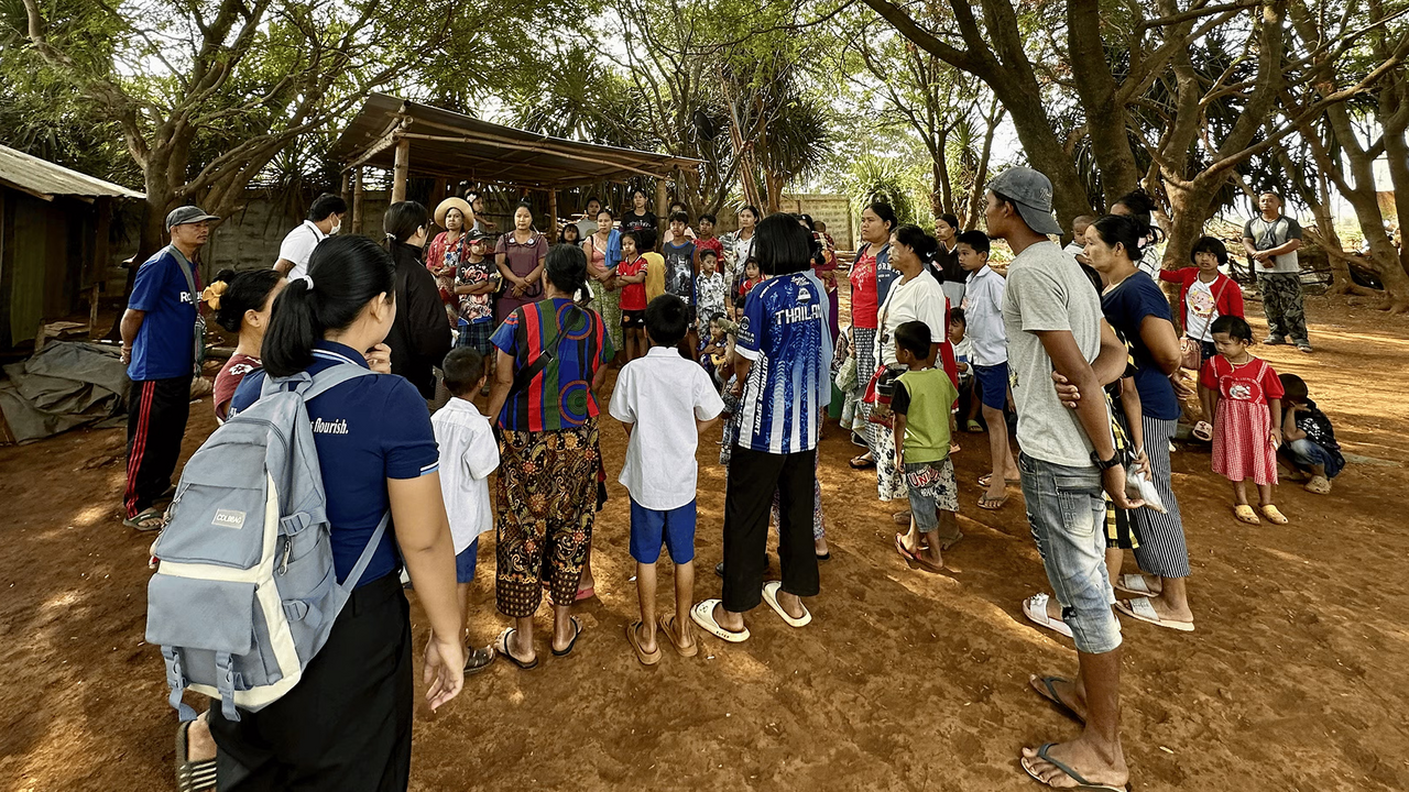 A student wearing a backpack gathers with a community