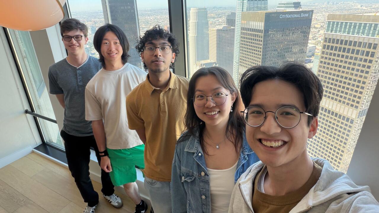Atoms co-op students pose for photo at the Atoms office with cityscape in the overshoot