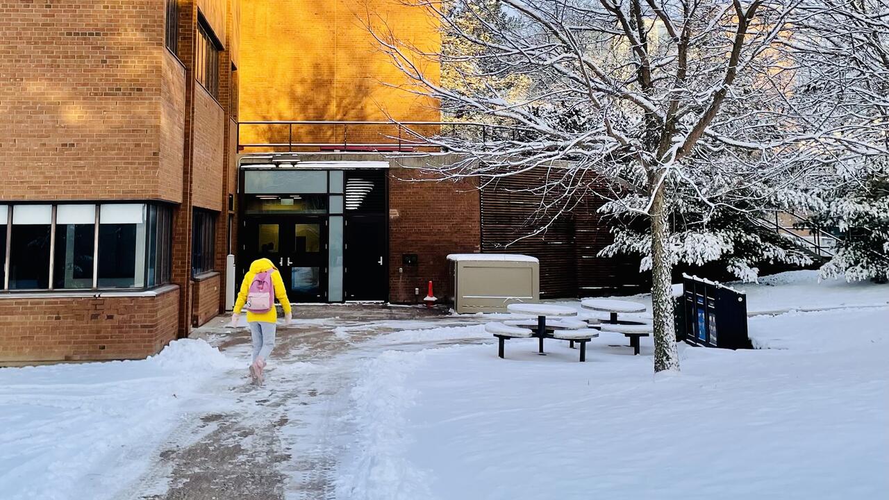 Student on Waterloo campus with snowy paths