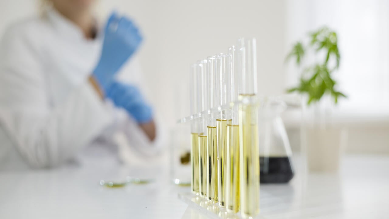 Female scientist in a laboratory working with cbd oil extracted from a medical marijuana plant.