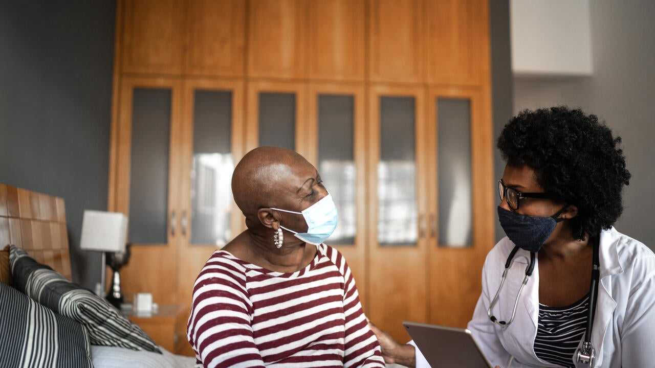 A medical personnel speaks with a patient. 