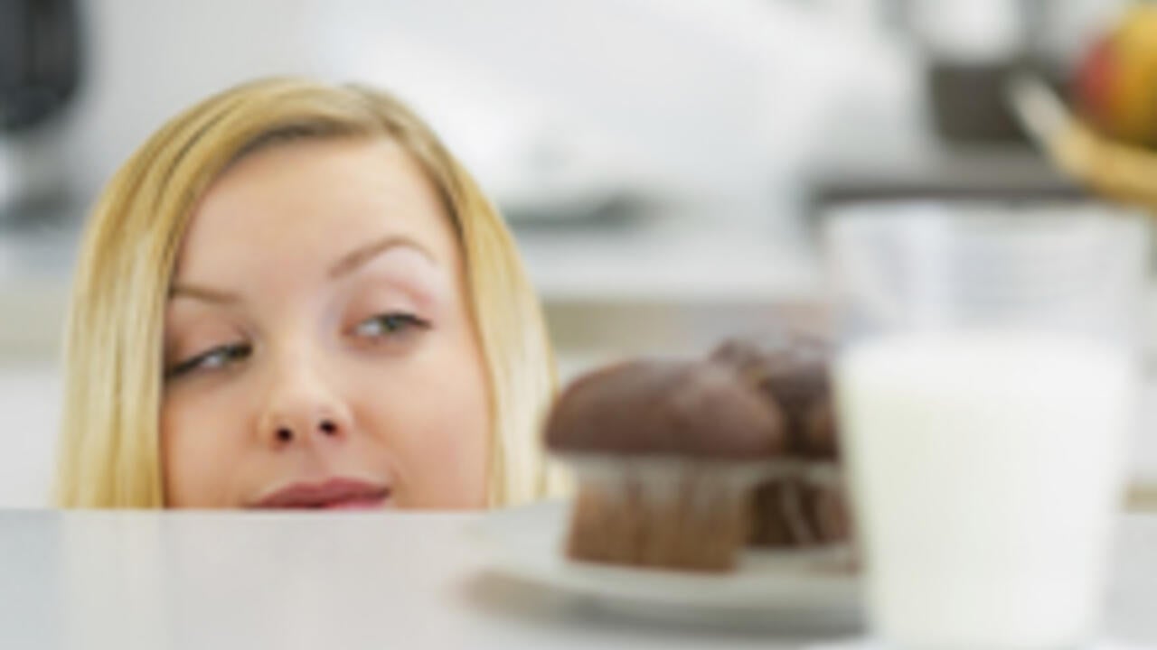 Woman eyeing up a cupcake