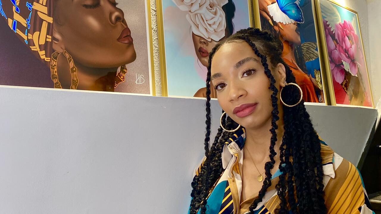 Kemahee Baker poses with her paintings