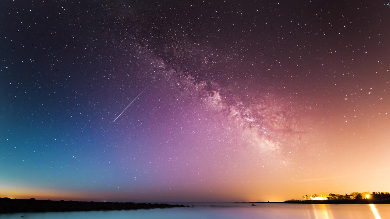 Galaxy seen in evening sky with shooting star