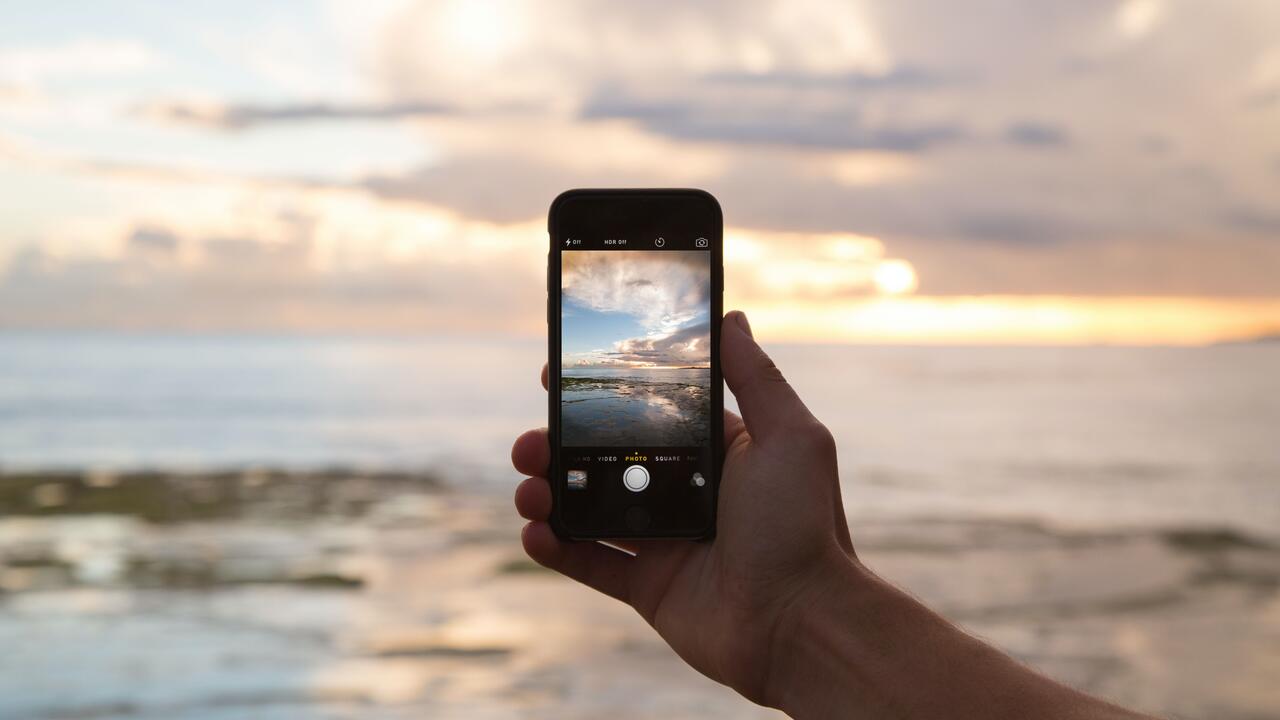 Using a phone to take a photo of the horizon. 