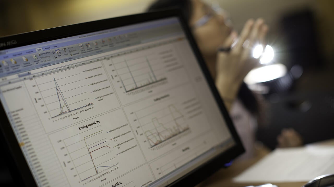 Image of a computer with line graphs in an excel sheet