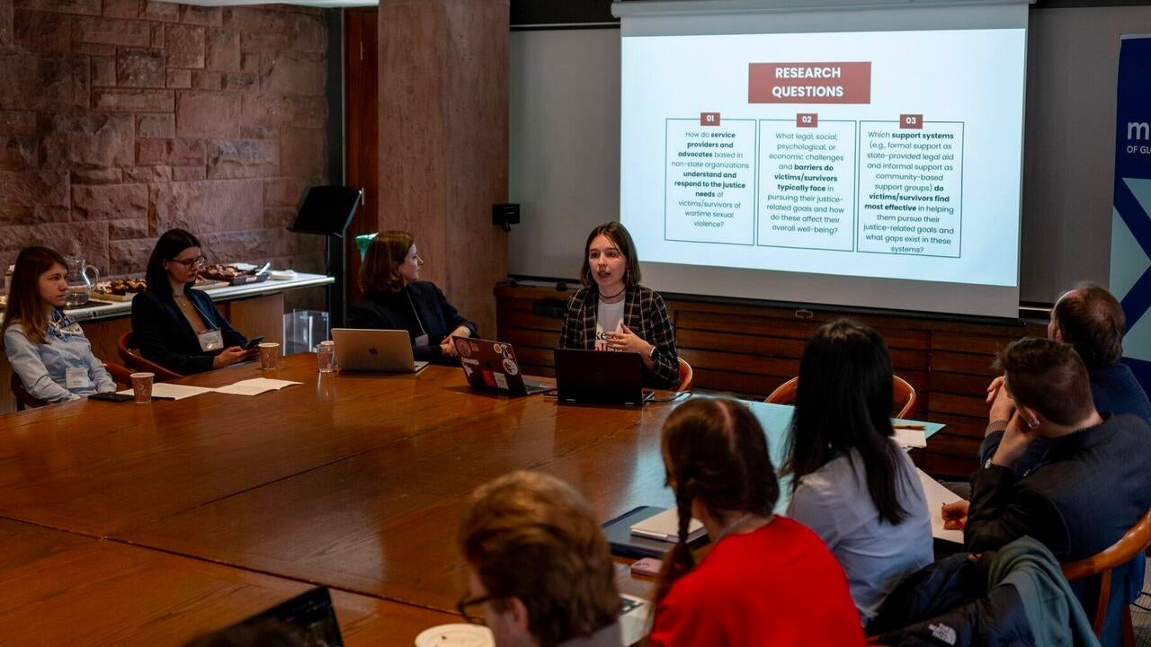 Student presenting to others around boardroom table
