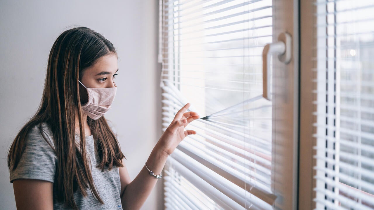 Girl in face mask at home during virus