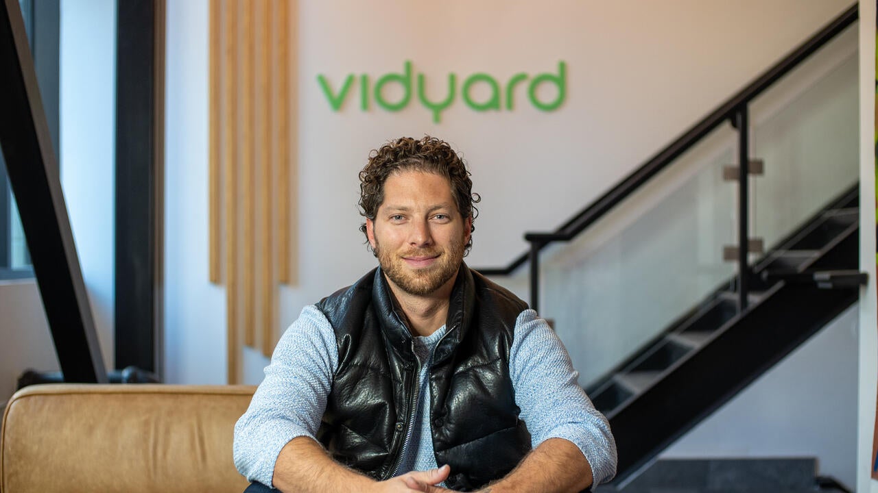 Michael Litt sitting on a couch in front of the Vidyard sign