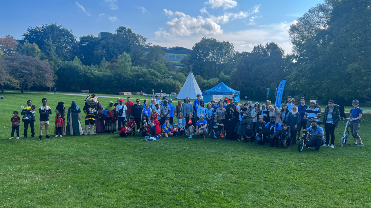 Refugee families, along with United College's and Reception House's staff and volunteers pose on campus lawn